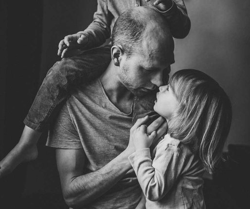 Ein Vater kuschelt innig mit seinen Kindern